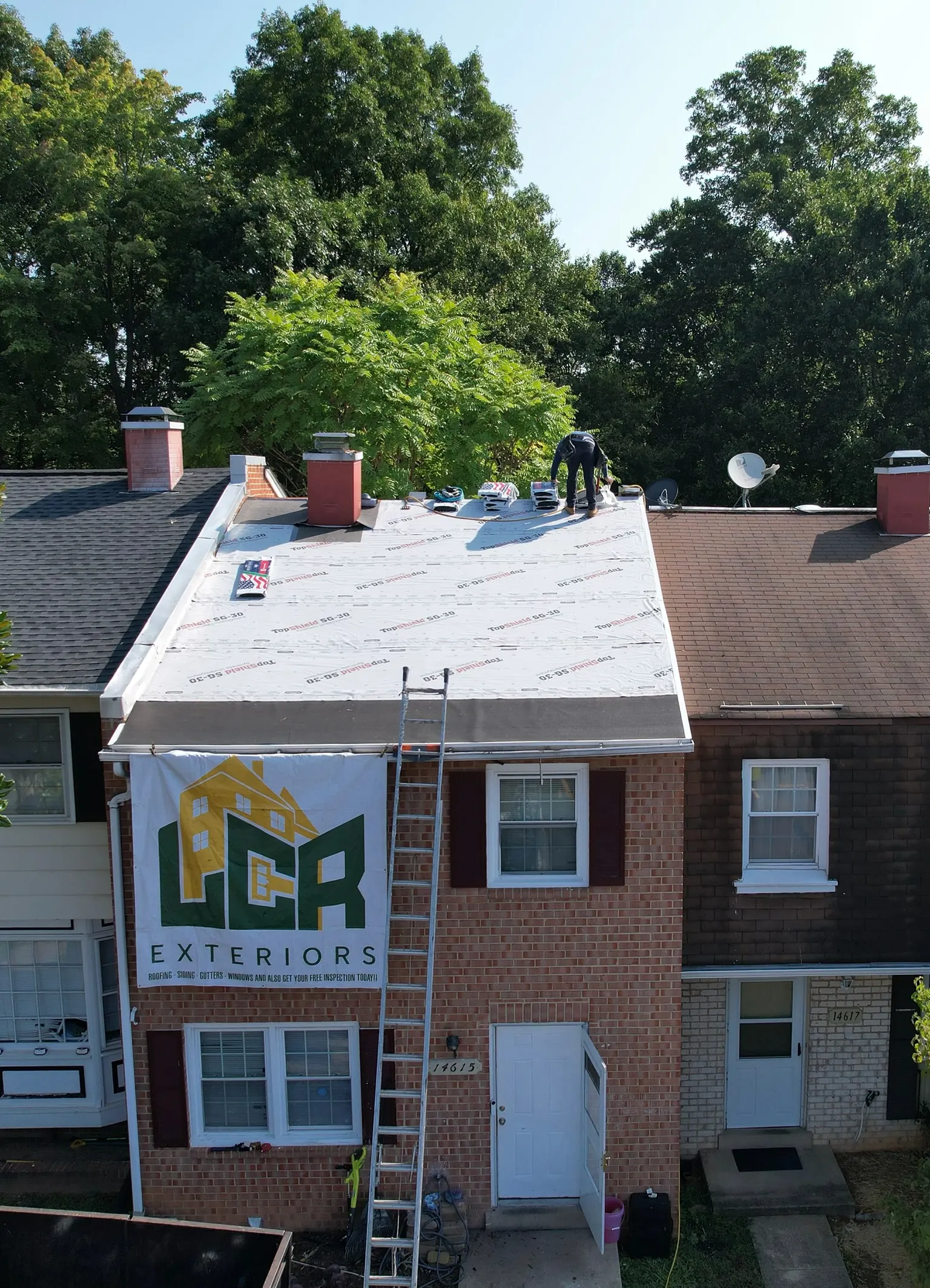 Drone view of an LCR install day — underlayment down and the LCR banner on the lawn